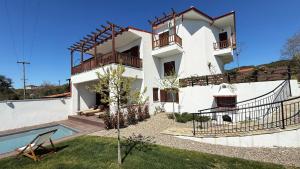 a villa with a swimming pool and a house at Athos Villas in Ouranoupoli
