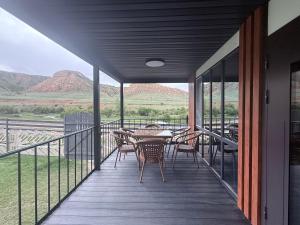a balcony with a table and chairs and mountains at Opensky-kolsay 2 in Saty