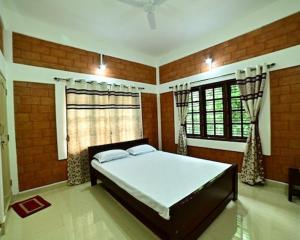 a bedroom with a large bed in a room at Assraya stay in Kushālnagar