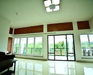 a living room with large windows and a couch at Assraya stay in Kushālnagar