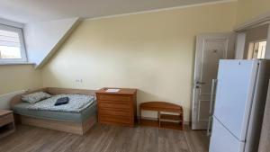a small bedroom with a bed and a refrigerator at DelMar in Klaipėda