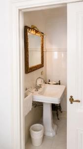 ein weißes Badezimmer mit Waschbecken und Spiegel in der Unterkunft White Suite Capri in Capri