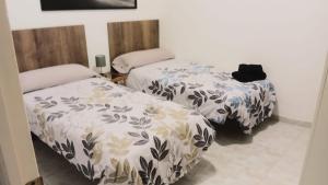 two beds sitting next to each other in a room at Marvelous flat in the city center in Ceuta
