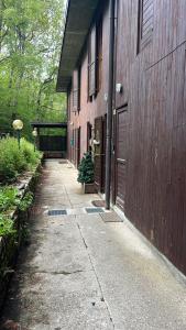 a walkway next to a brown building with a door at Appartamento Tulipano in Nevegal
