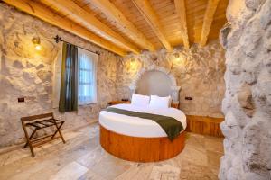 a bedroom with a bed in a stone wall at The Calypso Cave in Ürgüp +87 photos