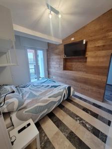 a bedroom with a bed and a flat screen tv at Mamma Lucia accommodation in Borno