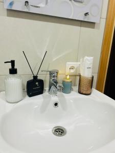 a bathroom sink with soap and candles on it at Kitesa's apartment with two bedrooms in Mtskheta +26 photos