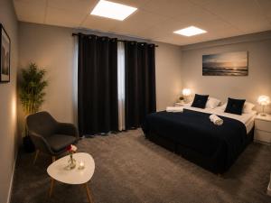 a hotel room with a bed and a chair at Tjarna Hotel in Keflavík