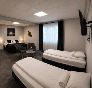 a hotel room with two beds and a couch at Tjarna Hotel in Keflavík