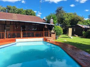 a swimming pool in front of a house at SMAPERS GUESTHOUSE in Brits