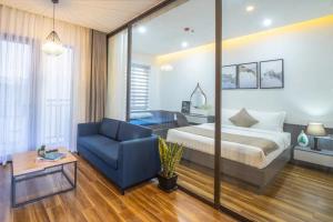 a hotel room with a bed and a blue couch at Seasol Beach Boutique hotel in Danang
