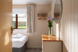 a bathroom with a vase of flowers on a table at L23 Cormorant in Truro