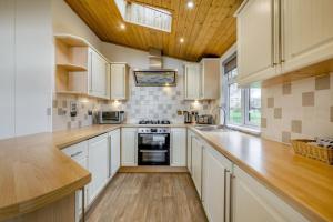 a kitchen with white cabinets and a wooden ceiling at Field View 2 bed 'S'- Sycamore in Eye