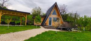 a small house with a truck in front of it at A Frame YRA cu ciubar in Câmpulung