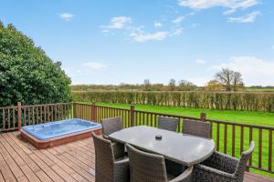 a deck with a table and chairs and a hot tub at Field View 2 bed 'S'- Sycamore in Eye