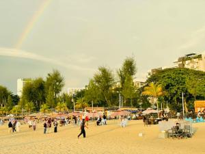 a group of people walking on a beach with a rainbow at Ferringhi Beach Guesthouse-3bed in Batu Ferringhi