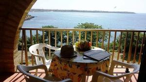 a table with a hat sitting on top of a balcony at Cala Longa Poseidon Beach Resort in Casa dello Stumio