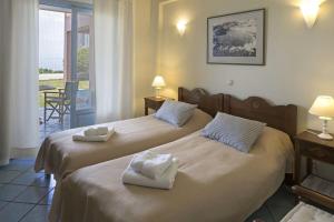 two beds in a hotel room with towels on them at MIRA Resort Maizonettes in Lefkada +28 photos