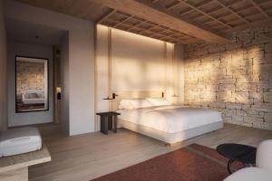 a bedroom with a bed and a stone wall at Castilla Termal Palacio de Avellaneda in Peñaranda de Duero +4 photos