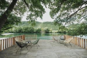 Eine Gruppe von Stühlen steht auf einer Terrasse neben einem Fluss in der Unterkunft Home Libre in Bosanska Krupa