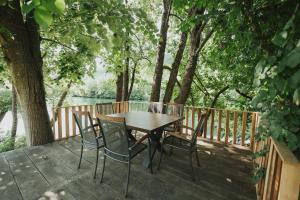 Ein Tisch und Stühle auf einer Terrasse mit Blick auf einen See in der Unterkunft Home Libre in Bosanska Krupa