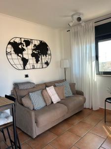 a living room with a couch and a world picture on the wall at AtticoCinque in Bari
