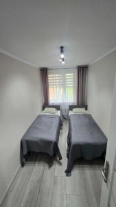 a room with two beds and a window at Via VOLTA 2025 Refresh 2 Bedroom Apartment in Płock