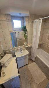 a bathroom with a sink and a tub and a mirror at Via VOLTA 2025 Refresh 2 Bedroom Apartment in Płock
