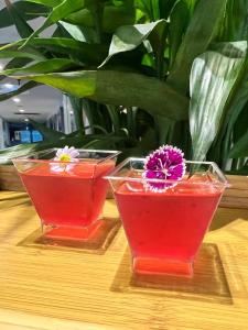 zwei Gläser Rotwein mit einer Blume darin in der Unterkunft Crystal Suites Suvarnbhumi Airport in Lat Krabang