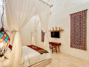a bedroom with a canopy bed and a table at Hafrana Villa by AGATA - 700sqm 2BR Villa with Private Pool & Jacuzzi in Sidemen +12 photos