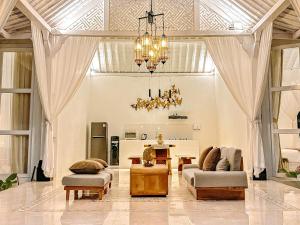 a living room with a chandelier and a table at Hafrana Villa by AGATA - 700sqm 2BR Villa with Private Pool & Jacuzzi in Sidemen