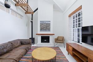 a living room with a couch and a table at Modern Cozy Upper Wynberg Cottage in Cape Town