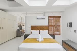 a bedroom with a large white bed with a wooden headboard at Modern Cozy Upper Wynberg Cottage in Cape Town
