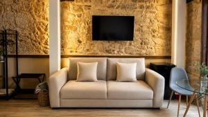 a living room with a couch and a tv at Rua Mayor MSuites in Salamanca