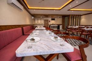 a long table in a restaurant with tables and chairs at Maa Trinayani Palace in Katra