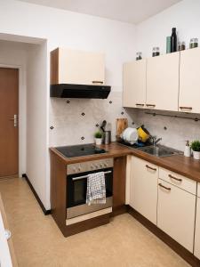 a kitchen with white cabinets and a stove and a sink at StaySpace in Graz
