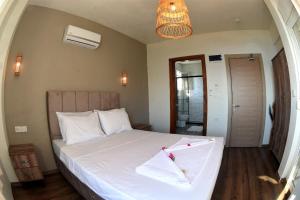 a bedroom with a large bed with white sheets at 7 Oda Söğüt in Marmaris