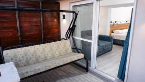 a room with a bench and a room with a bedroom at Bluetopas Otel in İskele +3 photos