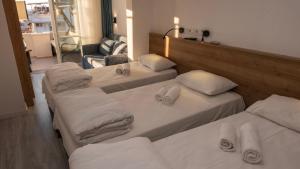 a group of three beds in a room at Bluetopas Otel in İskele