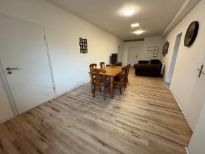 a dining room and living room with a table and chairs at Ferienwohnung Mimi in Wernigerode