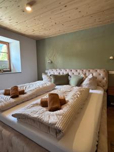 a large bed with two pillows on it in a room at Landhaus am Weissensee in Füssen