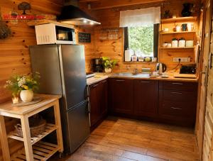 a kitchen with a stainless steel refrigerator and wooden walls at Wierzbowy Jar- kameralny domek przy lesie w Rudawach Janowickich stworzony dla osób szukających spokoju in Janowice Wielkie +18 photos