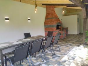 a table and chairs in a room with a brick fireplace at Pensiunea Balea Sat in Cârțișoara