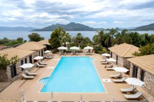 a view of the pool at a resort with chairs and umbrellas at Almyra Holiday Village in Edipsos