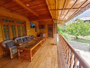 a porch of a house with a table and chairs at Himalaya Vista - 1km Uphill Hike from Main Road in Harsil