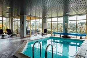 a swimming pool in a house with a pool table at Spa Hotel Ezeri in Sigulda