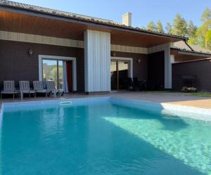 a swimming pool in front of a house at The Selo in Korostovat