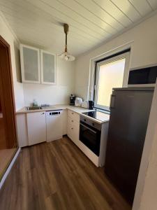 a kitchen with white cabinets and a black refrigerator at Ferienwohnung Max in Mürzzuschlag +8 photos