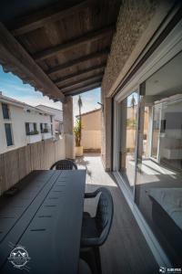 a patio with a table and chairs on a deck at Les Embruns - Mer - Terrasse in Le Grau-du-Roi