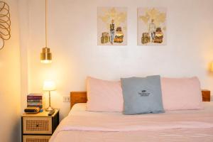 a bedroom with a bed with pink and blue pillows at Bintana Sa Paraiso in Mambajao +265 photos